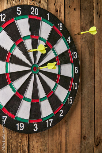 Darts game. Throwing darts at the target. Two yellow darts missed the target, one dart missed the target