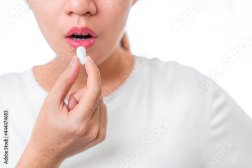 Asian woman taking white pill need treatment isolate on white background, healthy treatment concept, Selective focus.