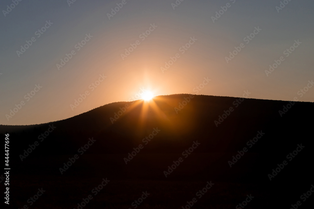 landscape with the sun rising after the silhouette of a mountain landscape with the sun rising after the silhouette of a mountain