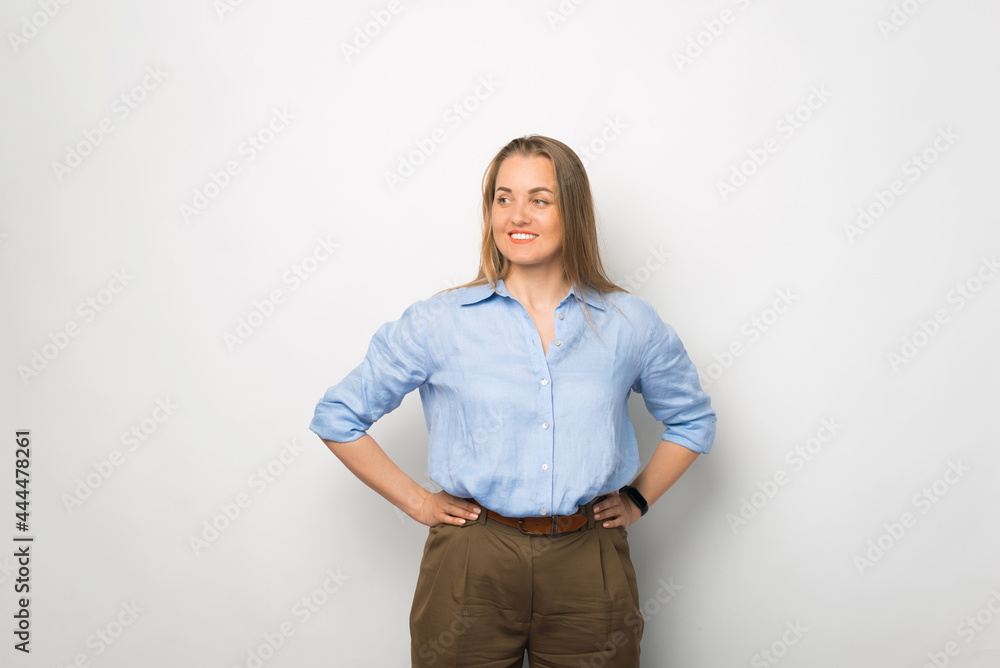 Portrait of a young businesswoman holding her hands on her waist over white background. Business staff. Portrait of a young businesswoman holding her hands on her waist over white background. Business staff.