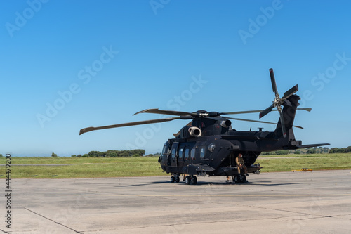 Schilderij op canvas A modern American military helicopter, ready to fly for a tactical operation, is on the runway