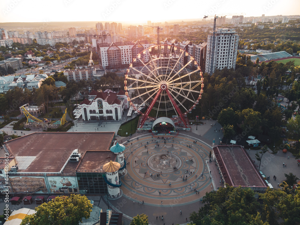 Ferris wheel spinning aerial sunset view in Kharkiv city center, amusement Park of Maxim Gorky. High attraction for recreation and city observation
