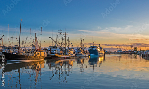 Fishing Boats in Marina and a reflection of a cloudy sky in water surface. This marina is located in the Steveston area of Richmond. 
