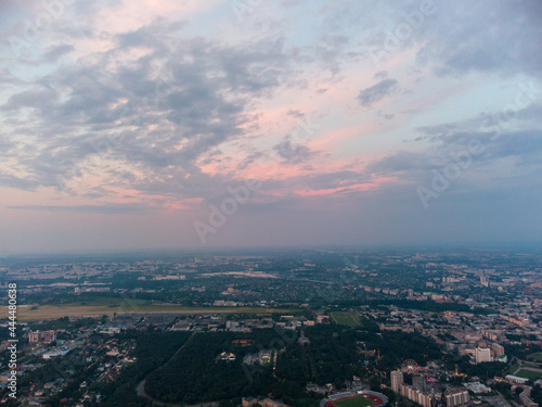 Aerial view of Kharkiv city center with Park of Maxim Gorky, stadium and residential multistory buildings with scenic sunset cloudy sky
