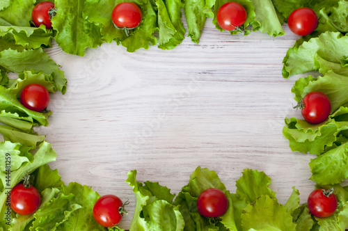 frame of fresh vegetables cherry tomatoes and lettuce salad on a wooden background. High quality photo
