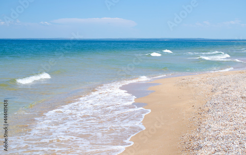 Waves on the sandy seashore are a beautiful summer background. Design of the background, photo wallpapers, covers, screensavers.