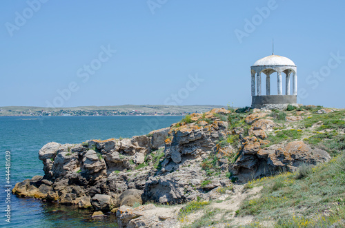 Antique gazebo on a stone cliff by the sea. Beautiful summer landscape. Design of the background, photo wallpapers, calendar, screen saver, cover.