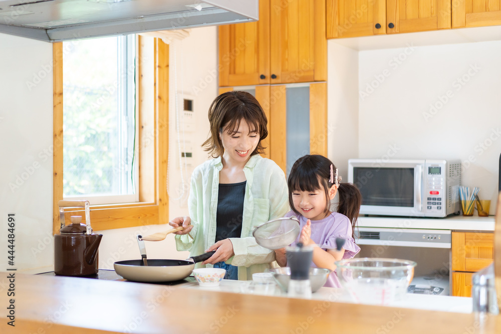 お母さんと一緒に料理をする小さな女の子 お母さんと一緒に料理をする小さな女の子