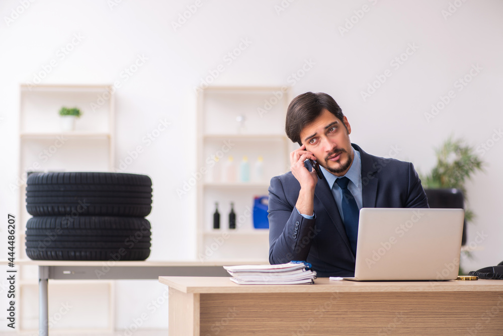Young man selling tires in the office Young man selling tires in the office