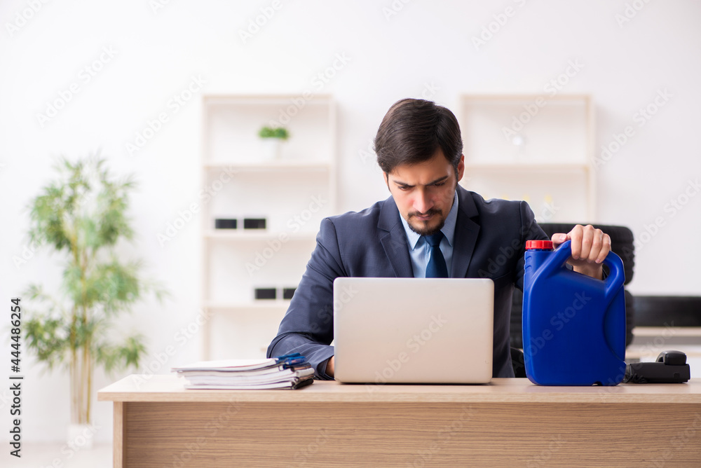Young man car equipment seller holding jerrycan Young man car equipment seller holding jerrycan