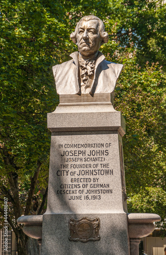 Johnstown, PA, USA - June 11, 2008: Joseph Johns statue in Central park with 2 cannons up front and fountain in back. Green foliage under blue sky with people present. photo