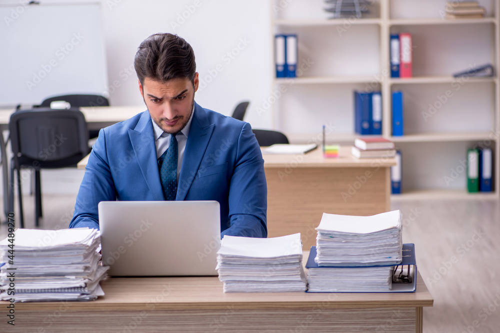 Young businessman employee and too much work in the office Young businessman employee and too much work in the office