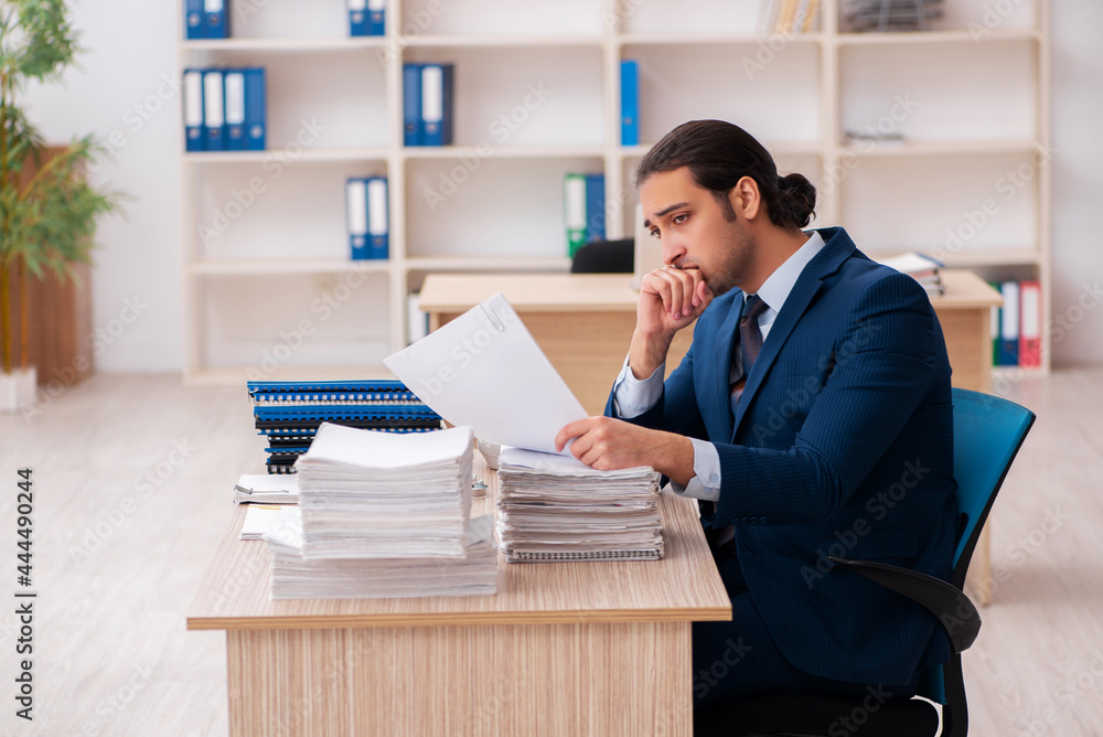 Young male employee unhappy with excessive work Young male employee unhappy with excessive work