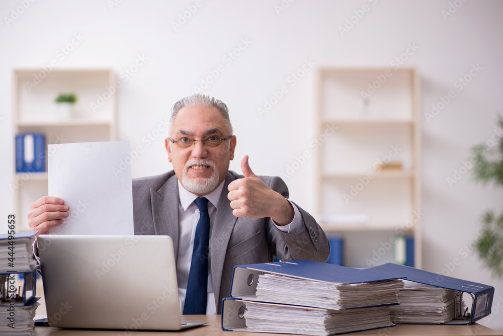 Old male employee unhappy with excessive work in the office