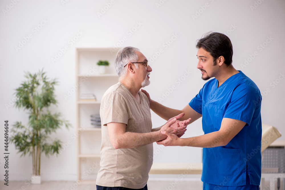 Old male patient visting young male doctor Old male patient visting young male doctor