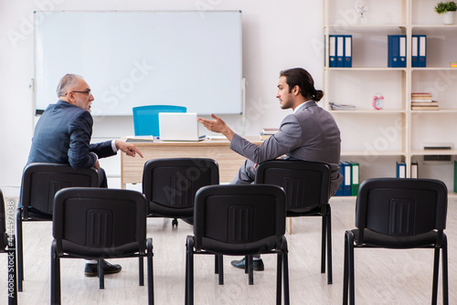 Two businessmen in the classroom in pandemic concept