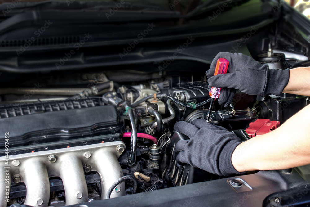 Technician use screwdriver remove a bolt of airflow sensor in the engine room car for check and cleaning in service concept Technician use screwdriver remove a bolt of airflow sensor in the engine room car for check and cleaning in service concept