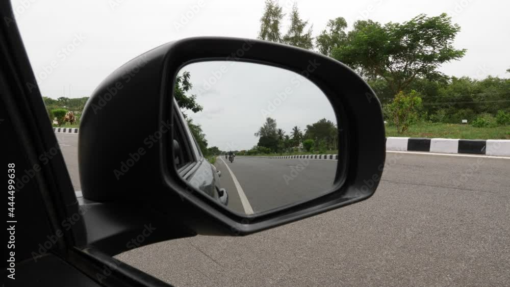 Close view of vehicles running in the side mirror of car Close view of vehicles running in the side mirror of car