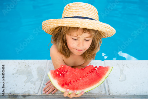Kid with watermelon smiling swimming in pool on summer on resort. Children with piece of water melon outdoor. Summer vacation and healthy eating concept.