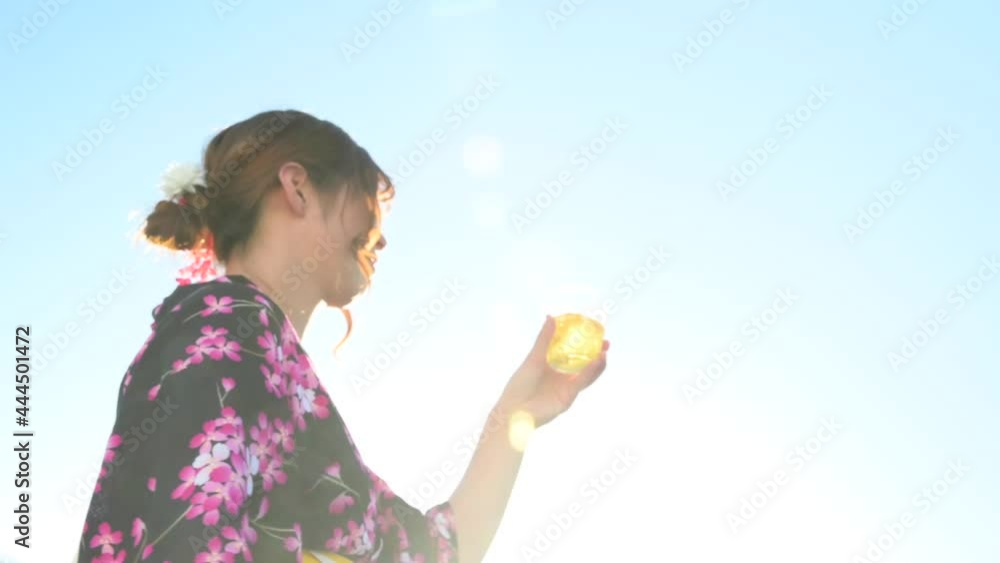 Japanese woman drinking cold barley tea in a yukata Japanese woman drinking cold barley tea in a yukata