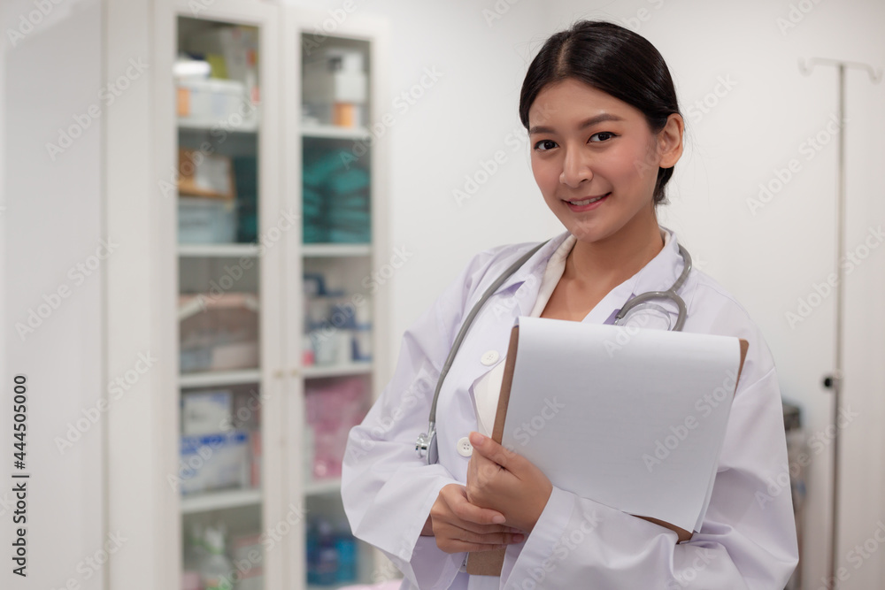 Asian Female Doctor With Stethoscope On Her Neck And Clipbroad In Her Hands,Doctor Stand in office Asian Female Doctor With Stethoscope On Her Neck And Clipbroad In Her Hands,Doctor Stand in office