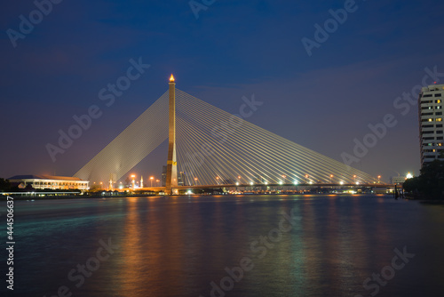 View of the cable-stayed bridge Rama VIII Bridge on the Chao Phraya river in the evening illumination. Bangkok, Thailand