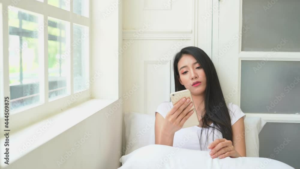 happy woman use smart phone ceel phone video call to her friend inbedroom on morning happy woman use smart phone ceel phone video call to her friend inbedroom on morning