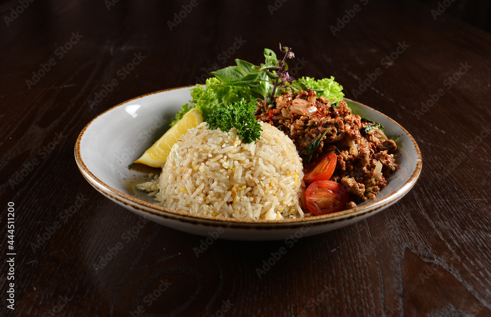 Thai style egg fried rice with spicy minced meat quorn and sliced of lemon asian vegetarian menu on wood table Thai style egg fried rice with spicy minced meat quorn and sliced of lemon asian vegetarian menu on wood table