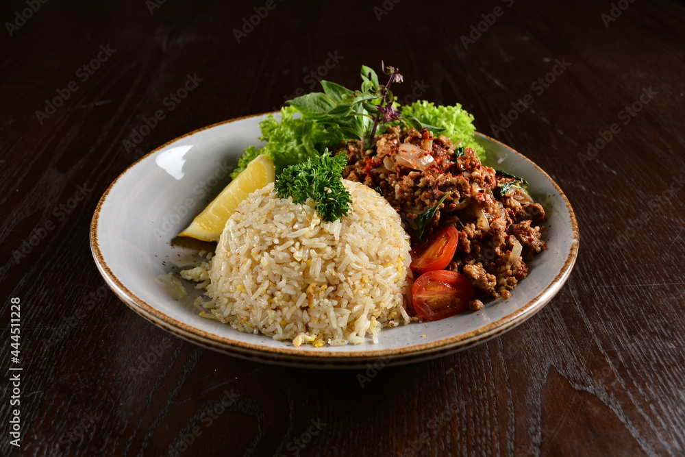 Thai style egg fried rice with spicy minced meat quorn and sliced of lemon asian vegetarian menu on wood table Thai style egg fried rice with spicy minced meat quorn and sliced of lemon asian vegetarian menu on wood table