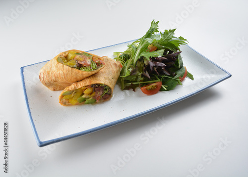vegetarian pan tortilla wrapped with salad and dressing on white background vegan halal menu