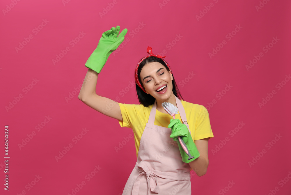 Young housewife with brush on pink background Young housewife with brush on pink background