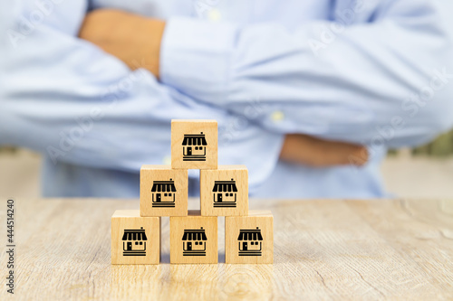 Franchise, Close-up cube wooden toy block stack in pyramid with franchises business store icon for standard and best quality for business growth and branch expansion and bank loan.