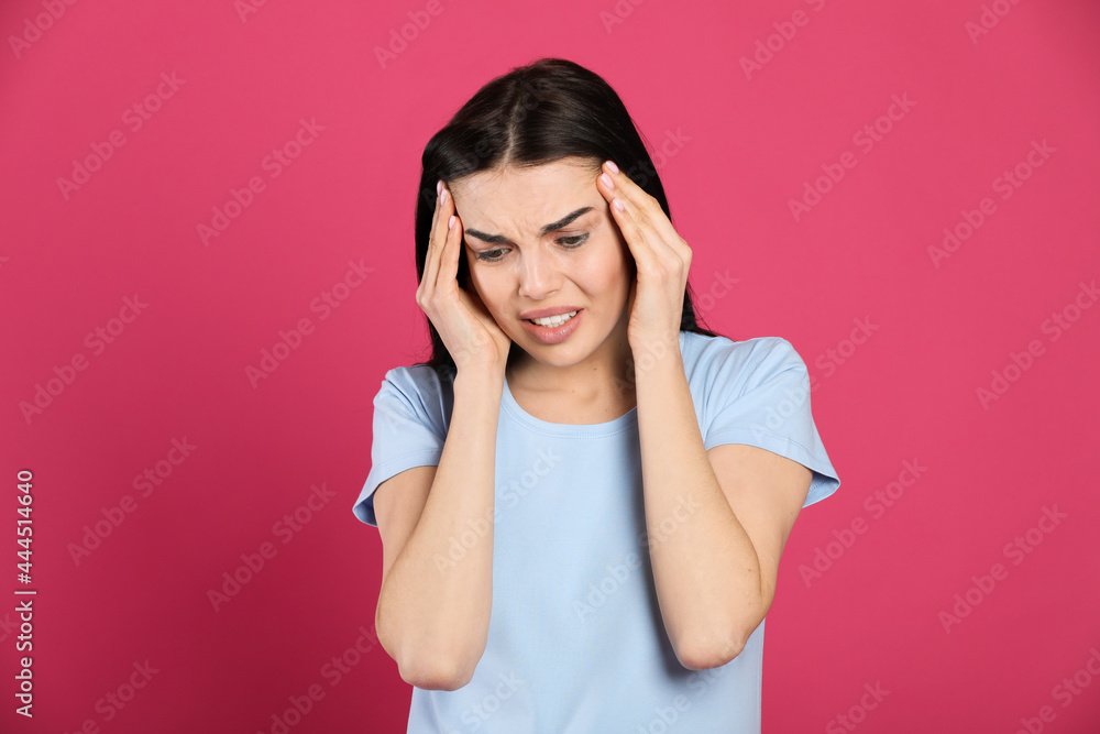 Woman suffering from migraine on pink background Woman suffering from migraine on pink background