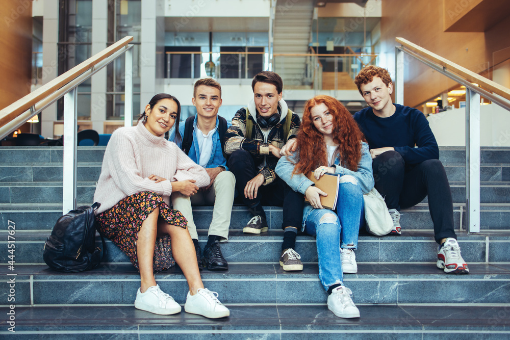 Fototapeta premium Smiling young people on college steps