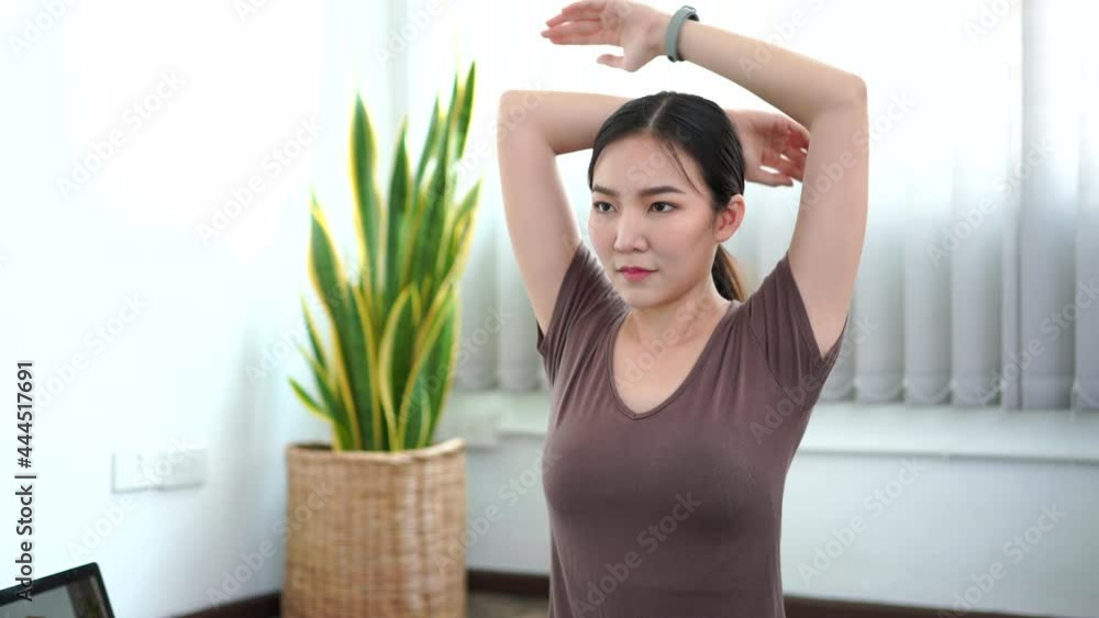 A calm woman having concentration to do yoga in a peaceful living room. A calm woman having concentration to do yoga in a peaceful living room.