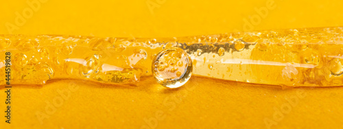 pure clear marijuana wax on yellow background, cannabis dab texture