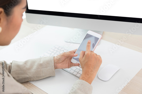 Close up of Woman hand Using a Smart Phone at office, Blank screen mobile phone for graphic display