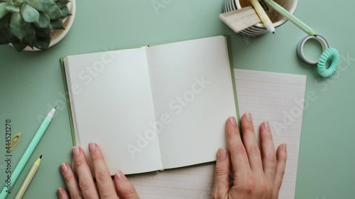 Hands open notebook with clean blank pages on the pastel blue background. Office desk,minimalism.Vertical video frame 9x16