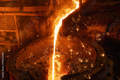 Cuadro en lienzo Liquid cast iron is poured into the ladle in a thin stream