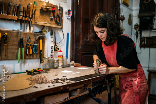 woman luthier making guitars in her musical instrument workshop