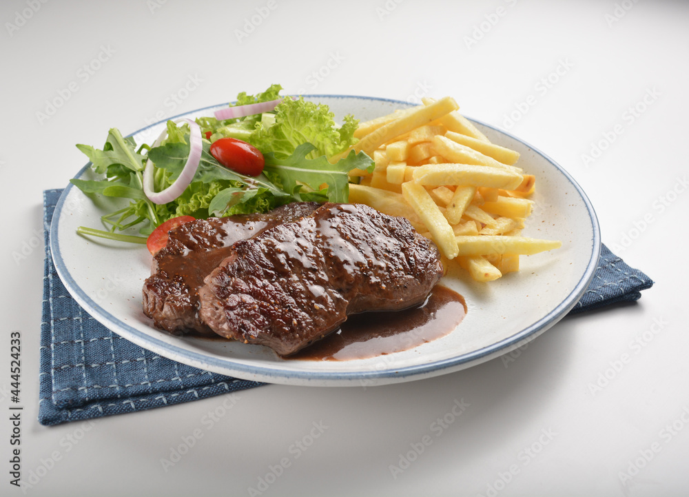 bbq grilled juicy wagyu beef tenderloin sirloin steak in brown black pepper sauce with French fries and vegetables salad dressing western cuisine menu