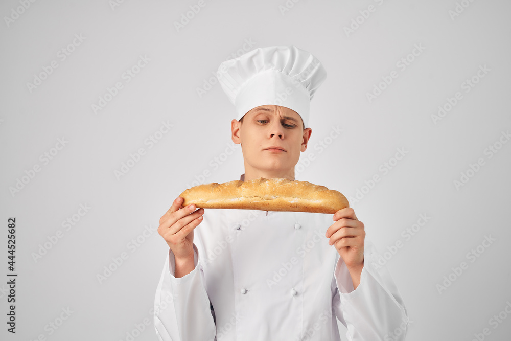 man in chef's clothes Professional with a baguette in his hands fresh product work man in chef's clothes Professional with a baguette in his hands fresh product work