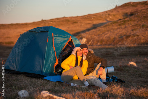 Couple camping on mountain at sunset
