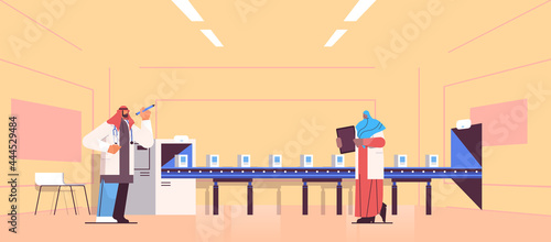 arabic operators team controlling medicine production filling on conveyor belt doctors checking quality of products