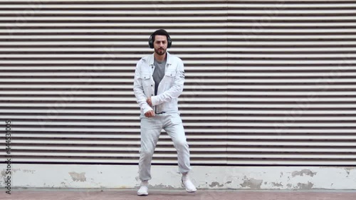 Cheerful and happy young businessman dancing on the modern background. 