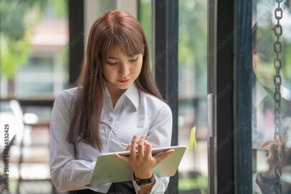 Pretty woman standing and using a tablet. Pretty woman standing and using a tablet.