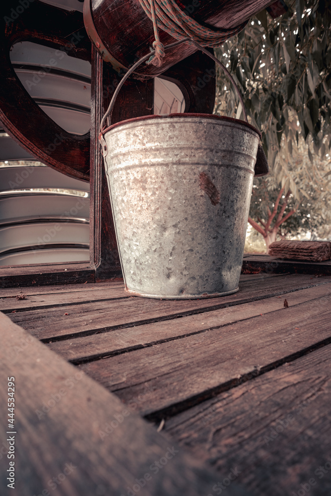 A metal bucket on an old wooden well A metal bucket on an old wooden well