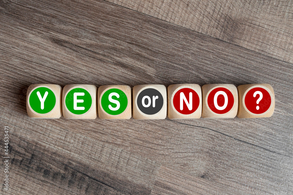 Fototapeta premium Cubes, dice or blocks showing the words YES or NO on wooden background