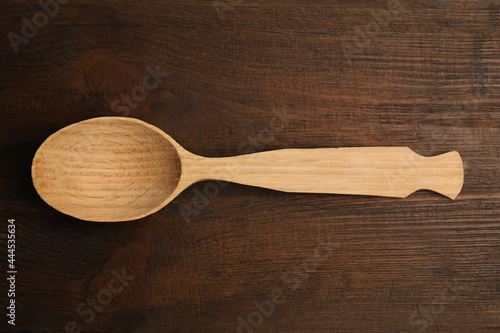 Handmade wooden spoon on rustic table, top view
