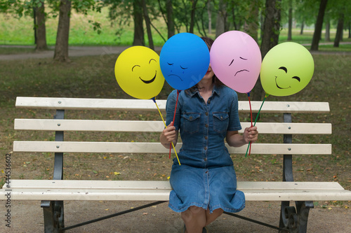 Woman holding air balloons with funny drawn faces. photo